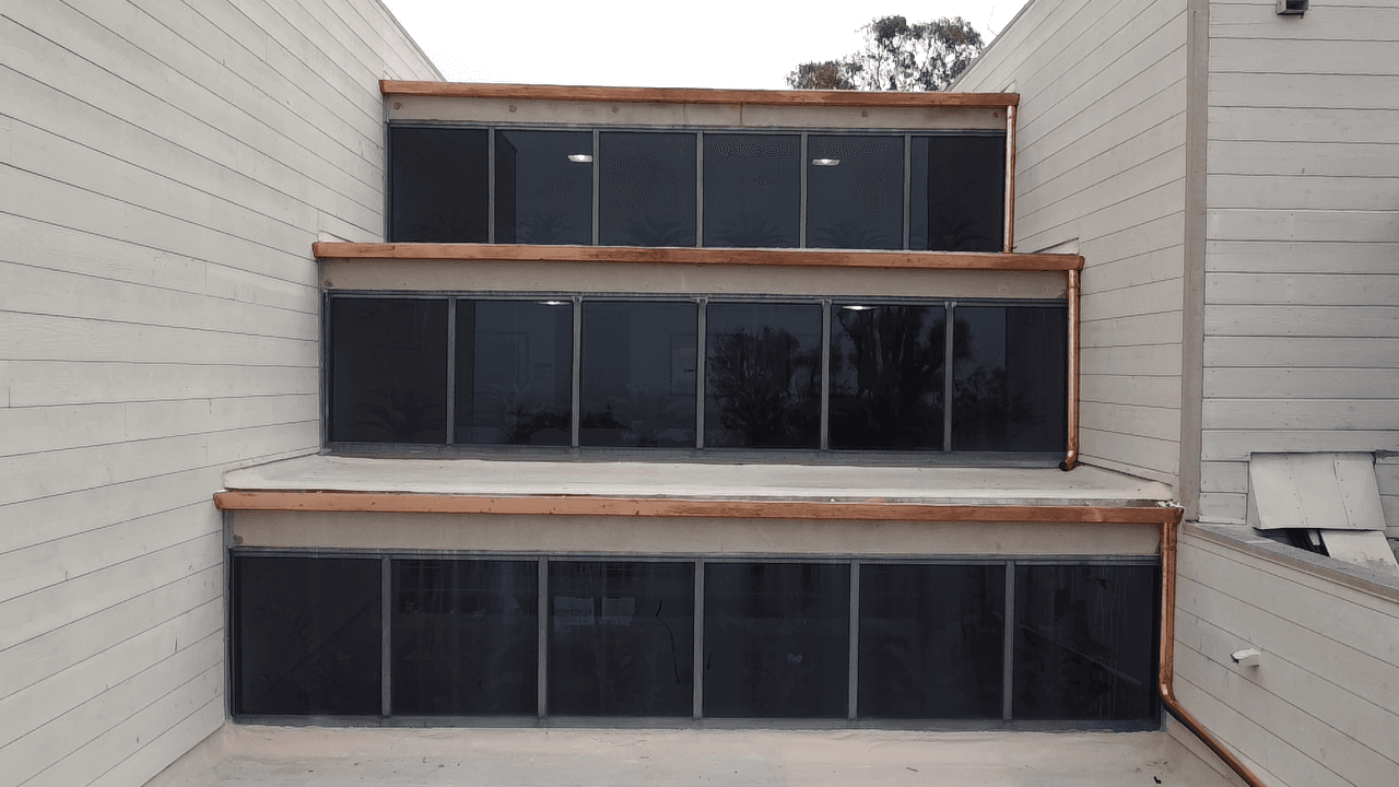 Custom copper half-round gutter installation on a multi-level Southern California home