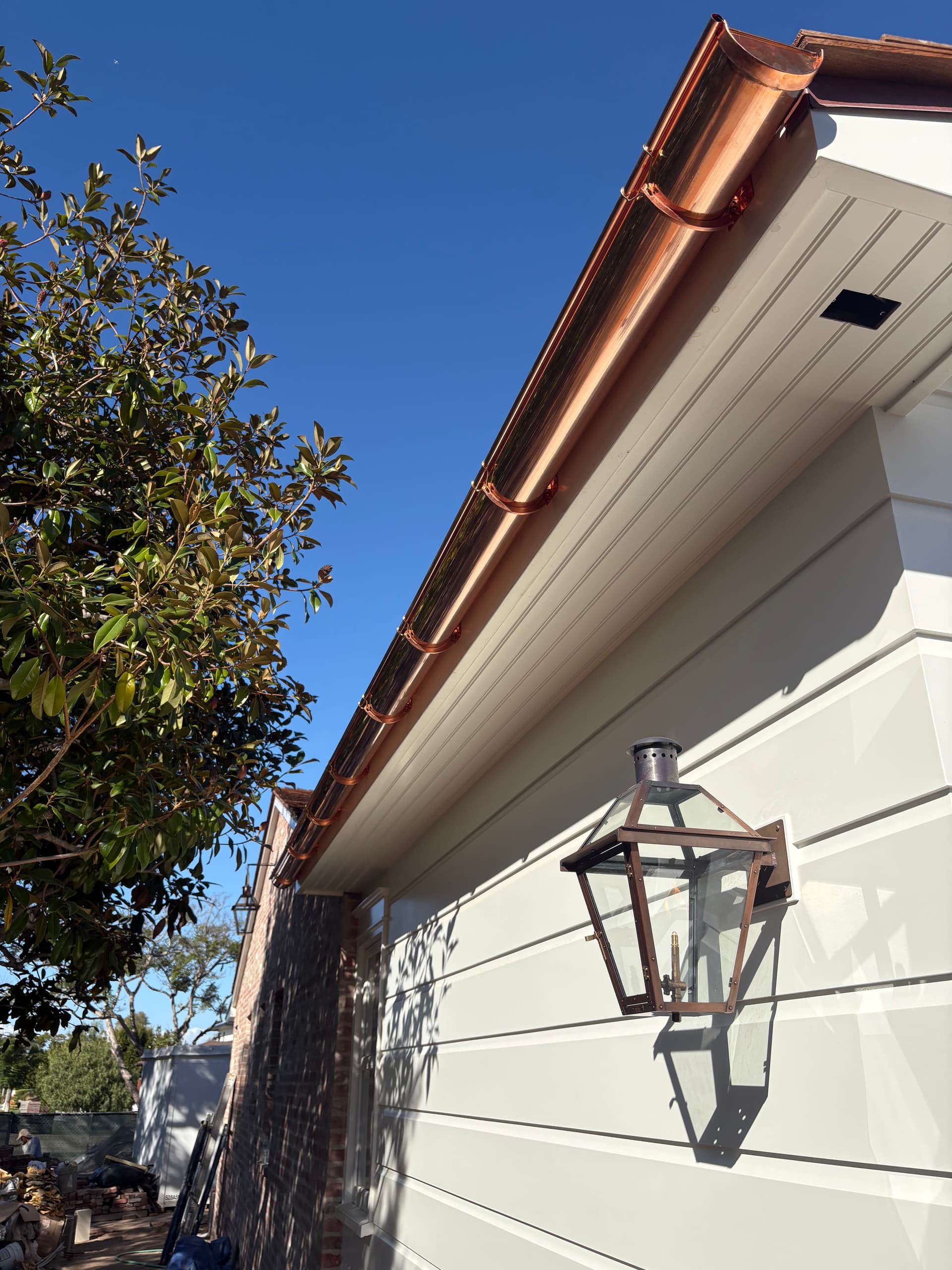 Copper half-round gutter system with brackets and lantern on coastal home