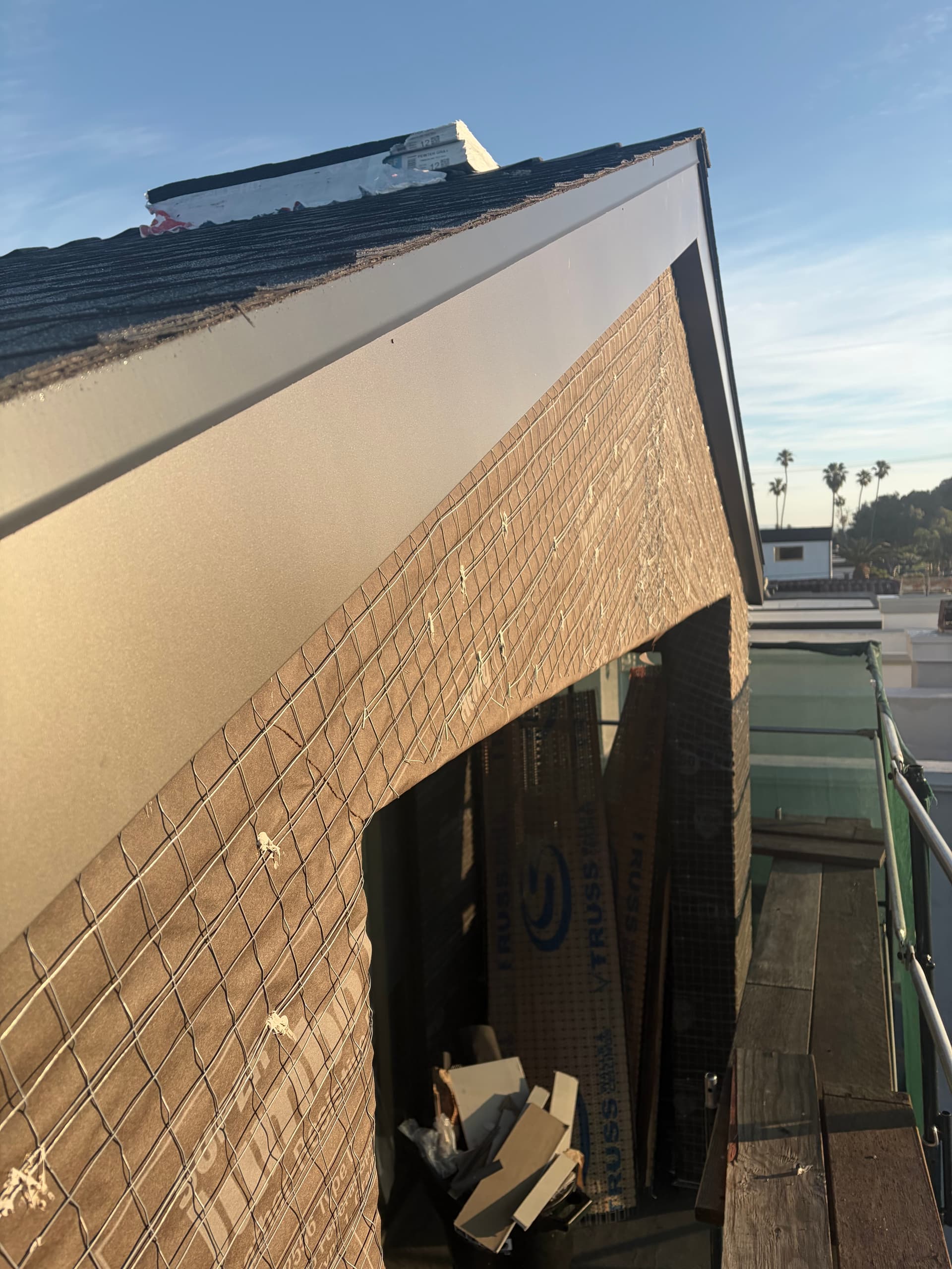 Completed aluminum fascia wrap corner detail on roofline with shingle roof