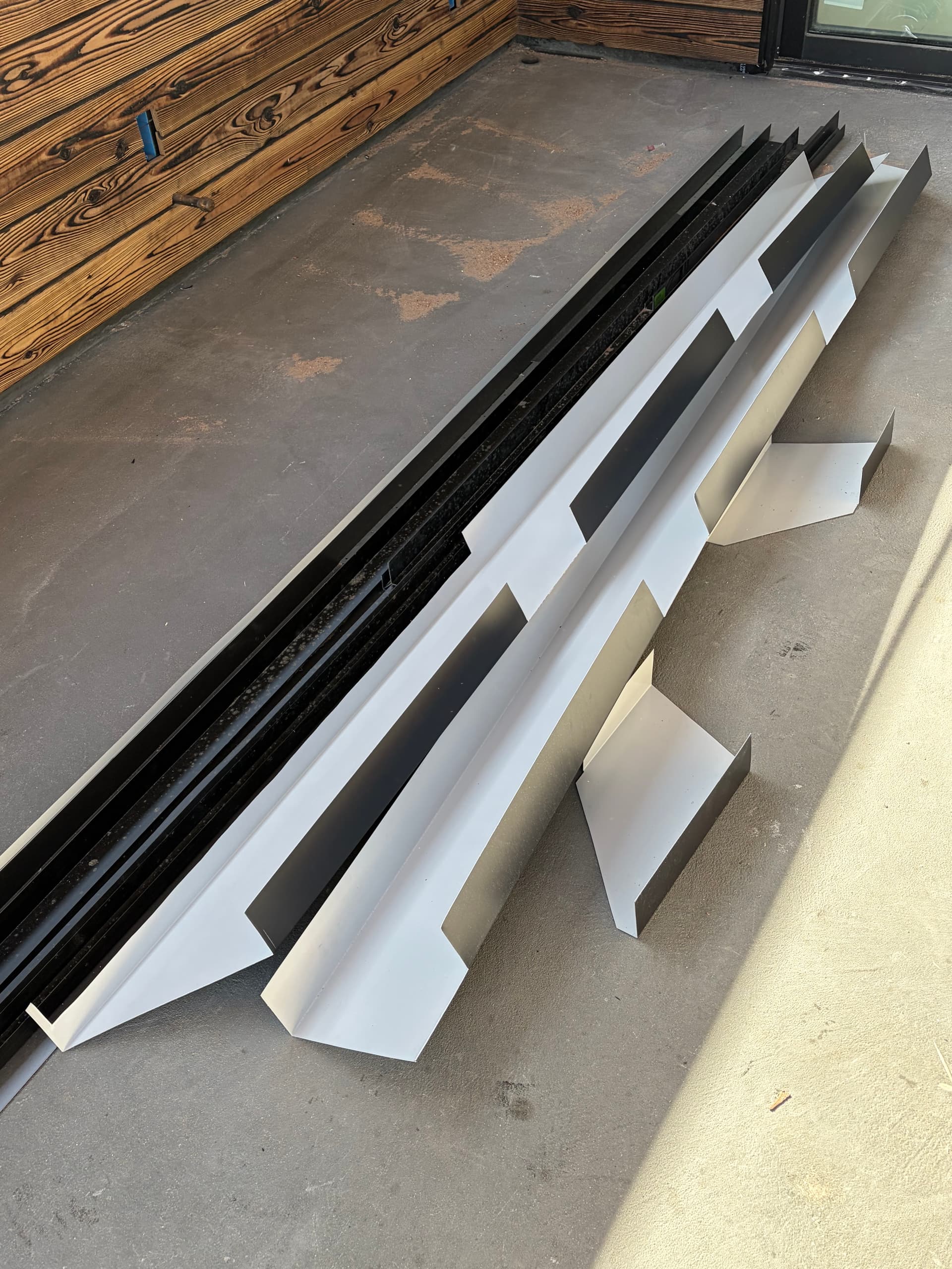Custom-fabricated aluminum fascia wrap pieces and rafter tail cladding ready for installation