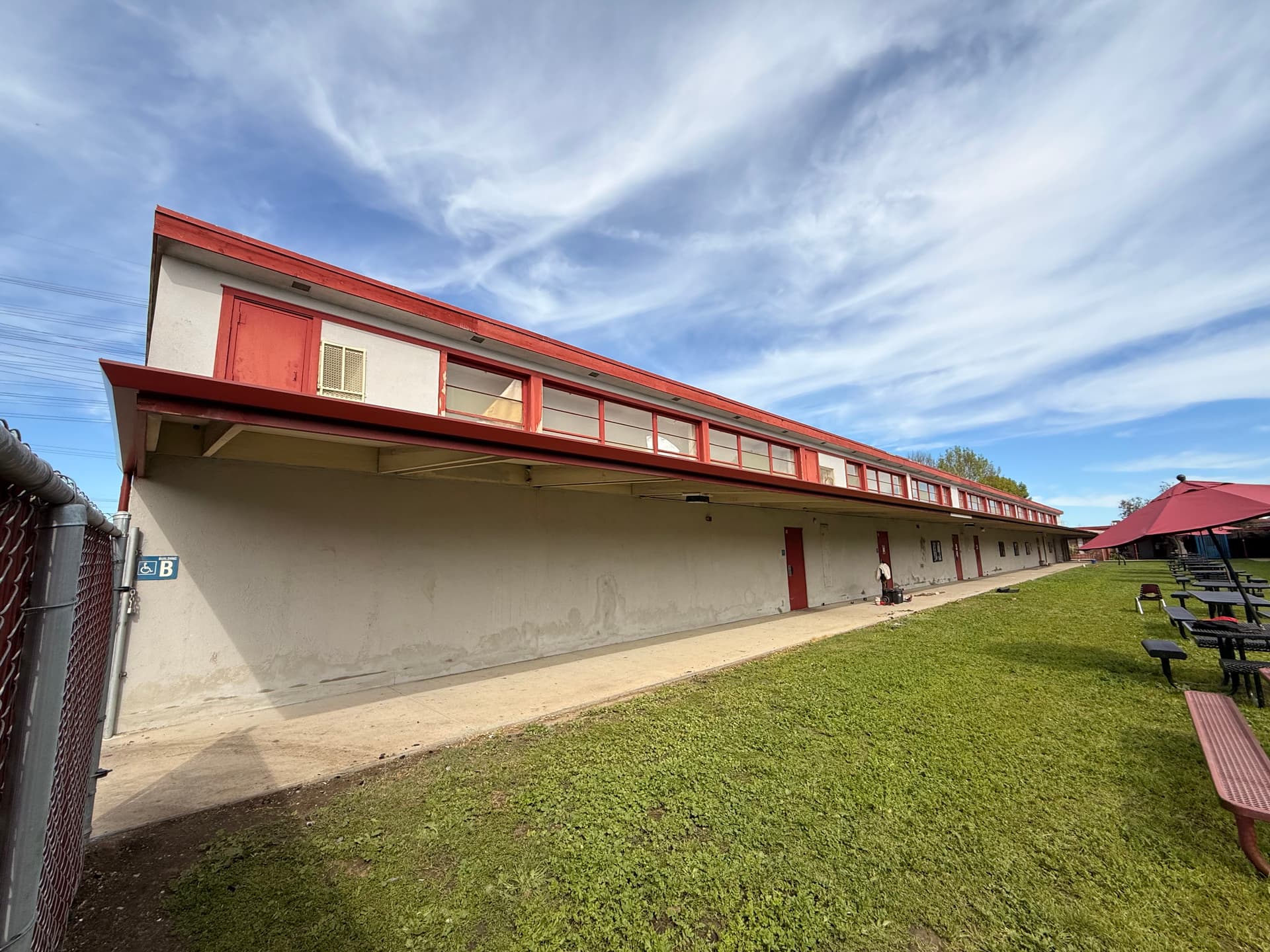 Commercial building gutter system with red fascia and full-length gutter run